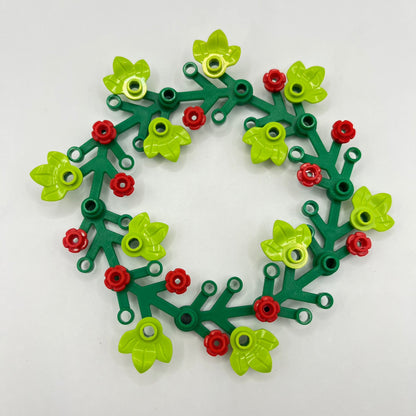 Decorative LEGO Christmas wreath made of green, red, and yellow pieces on a white background